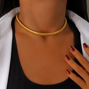Detailed view of a gold choker necklace with spiral texture on a female model neck