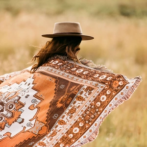 Detail of bohemian outdoor blanket with geometric patterns and fringe tassels