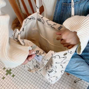 Detail of corduroy tote bag interior showing the magnetic snap closure and inner pocket