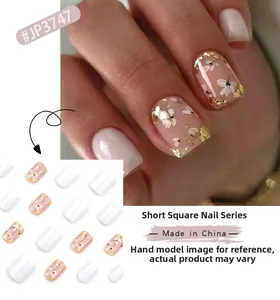 Short square press-on nails with white flower patterns and golden foil on pink base