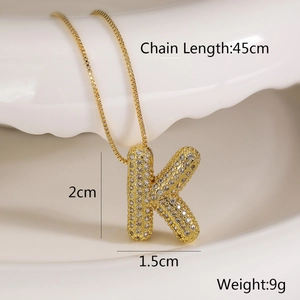 Detail view of gold letter K pendant necklace with cubic zirconia and size measurements