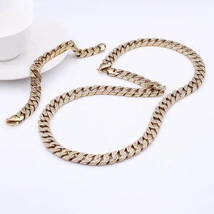 Détail de l'ensemble collier et bracelet gourmette cubaine dorée avec strass de style hip-hop