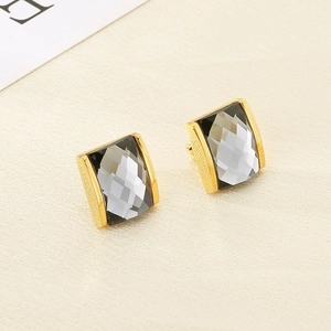 Detail of 18K gold plated square earrings with faceted grey-black crystal settings