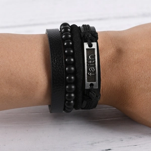 Detail of multi-layer leather bracelet set with beads and engraved metal faith charm