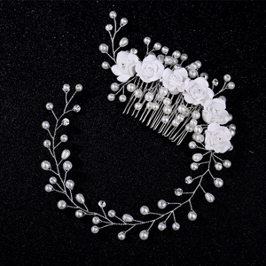 Detailed view of handmade ceramic rose hair comb with pearls and rhinestones on black background