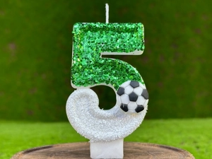 Gros plan d'une bougie d'anniversaire chiffre 5 vert pailleté sur le thème du football
