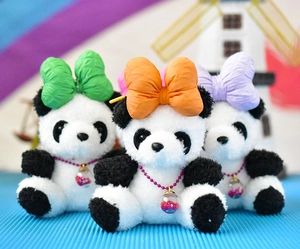 Close-up of three cute panda plush keychains with colorful bows and sparkling sequin ball pendants