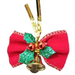 Close-up of red felt bow with green holly leaves, red berries, and a golden bell hanging
