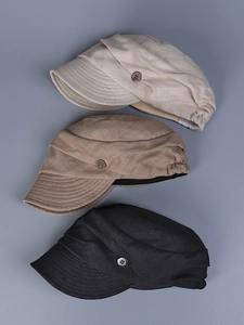 Detail of vintage linen newsboy caps in three colors with decorative wooden buttons