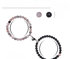 Detail of pink zebra stone and black matte bead bracelets with magnetic heart charm