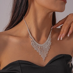 Detailed close-up of a silver water drop tassel necklace with rhinestones on a model