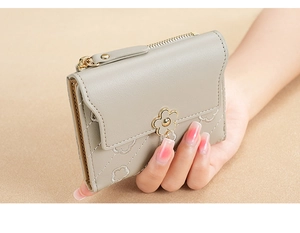 Detail of grey PU leather wallet featuring diamond pattern and gold flower buckle