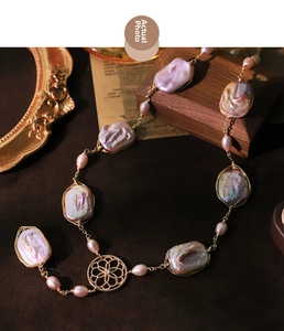 Detailed macro view of baroque pearl necklace with golden wire wrapping and retro metal ornament