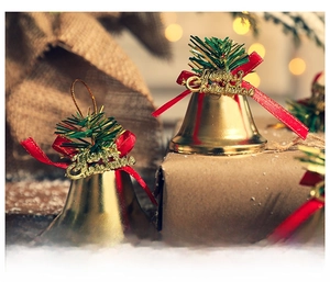 Golden Christmas bell pendant with red ribbon and green pine needles on festive background