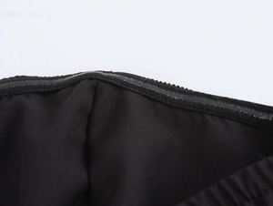Makroaufnahme des Silikon-Antirutschstreifens im schwarzen trägerlosen Kleid für Halt