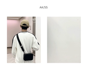 Detailed view of black nylon strap and matte synthetic fabric on small square crossbody bag