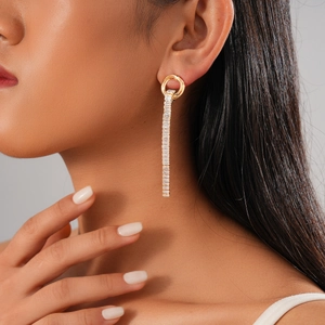 Model wearing gold tassel earrings with zircon studs showing a high-end luxury look