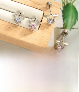 Macro detail of hollow star stud earrings with zircon inlay and titanium steel screw flat back