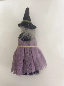 Detailed view of a handmade Halloween witch doll with purple gauze dress and pointed hat