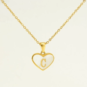 Detail of heart pendant with letter C and white shell inlay on golden titanium steel chain