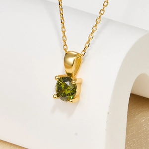 Macro shot of 925 silver necklace pendant with olive green stone and gold chain