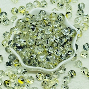 Macro shot of 8-10mm transparent glass beads with amber spots for DIY jewelry making
