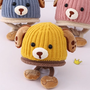 Detailed knit texture of baby hats with puppy ears and embroidered bone tassels