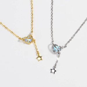 Detail of gold and silver heart planet necklaces with opal inlays and star fringe charms