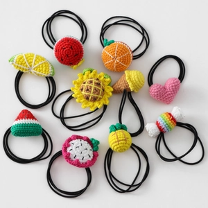 Detailed flat lay of handmade crochet hair ties with fruit and flower patterns