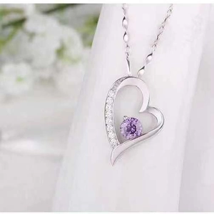 Macro view of S925 silver heart necklace with purple gemstone and sparkling zircons