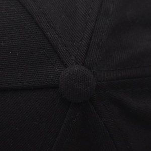 Macro detail of high-density stitching and fabric texture on a black cotton baseball cap