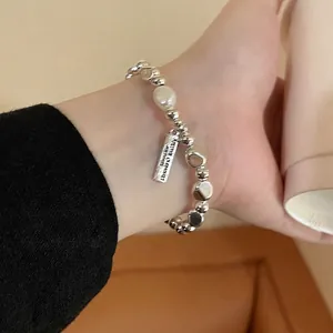 Detail of S925 silver beaded bracelet with baroque pearl and rectangular tag charm
