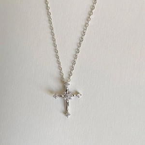 Macro view of silver cross necklace featuring brilliant white cubic zirconia stones
