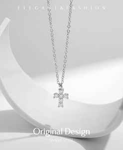 Detailed view of s925 silver cross pendant with sparkling moissanite on a minimal prop