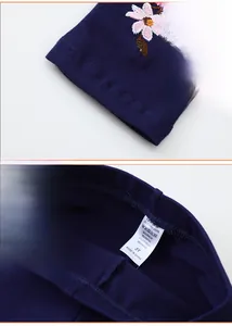 Détail de leggings bleu foncé pour enfants avec broderie florale et taille élastique avec étiquette