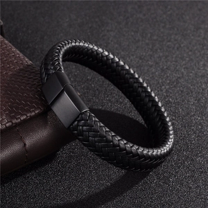 Braided black leather bracelet for men featuring a black magnetic metal clasp on dark surface