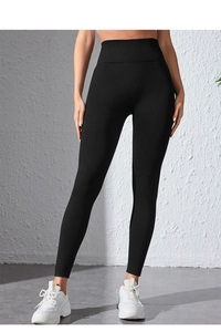 Detail of high-waist seamless black yoga pants showing tummy control and ribbed texture