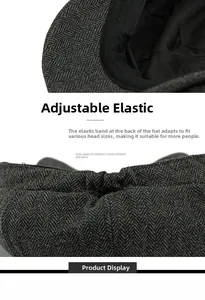 Detail view of adjustable elastic strap on dark gray herringbone wool newsboy cap