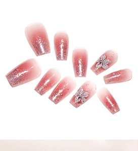 Detailansicht von rosa Blush-Nägeln zum Aufkleben mit 3D-Blumen und Glitzer-Akzenten.