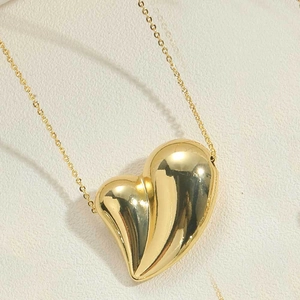 Macro d'un pendentif cœur 3D plaqué or 14K avec des rainures texturées uniques