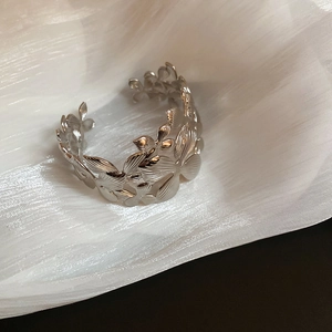 Vue détaillée du bracelet jonc argenté avec motifs ajourés de fleurs et de feuilles