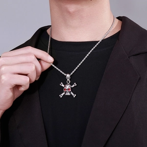 Detail of silver skull pendant with red gemstone eyes on a twist chain worn by a model