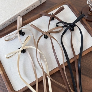 Chic faux leather bow hair clips with long ribbons in assorted earthy colors