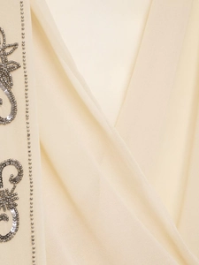 Close-up of beige georgette blouse with silver sequin embroidery and beaded V-neckline detail