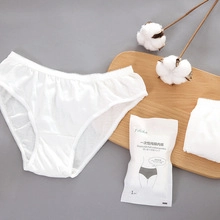 Detail showing individual packaging and texture of white disposable cotton travel underwear