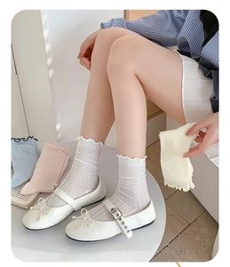 Detailed view of women's mesh socks with ruffled lace cuffs and vertical stripe texture