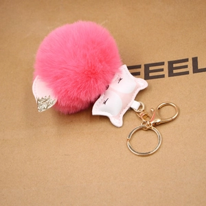 Close-up of pink faux fur fox keychain with glitter ears and golden metal lobster clasp