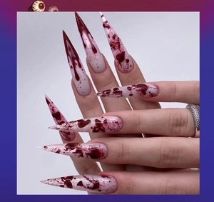 Detail of long stiletto press-on nails with realistic Halloween blood splatter design