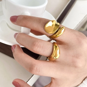 Minimalist gold fluid line and thick arc open rings displayed on hand for women