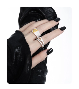 Detailed view of silver hollow diamond rings with orange stone and organic texture